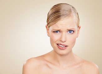 Image showing Portrait, doubt and space for beauty with woman in studio on beige background to question wellness. Confused, skincare and funny face for problem on mockup with young model at spa for dermatology