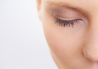 Image showing Eye, beauty and makeup with woman closeup in studio on white background for mascara cosmetics. Face, skincare and eyelashes of young model at spa with eyes closed for natural eyebrow dermatology