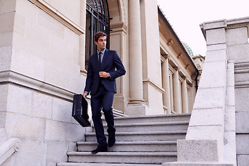 Image showing Business, briefcase and man walking on steps outside law firm in city with evening commute, sidewalk and court building. Businessman, lawyer or attorney on outdoor stairs with bag for urban travel.