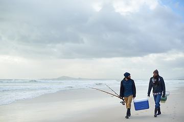 Image showing Clouds, fishing and men walking at ocean together with cooler, tackle box and holiday in mockup space. Beach, fisherman and friends with rods, bait or tools at waves on winter morning vacation at sea