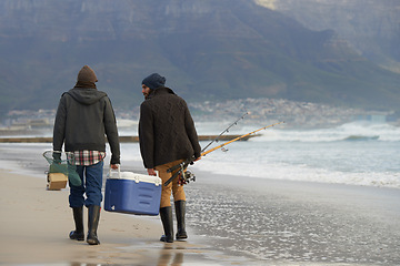 Image showing Ocean, fishing and men walking together with cooler, tackle box and holiday conversation from back. Beach, fisherman and friends with rods, bait and tools at waves on winter morning vacation at sea.