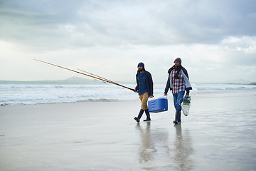 Image showing Winter, fishing and men walking on beach together with cooler, tackle box and holiday conversation. Ocean, fisherman or friends with rods, bait and tools in nature on morning vacation with cloudy sky