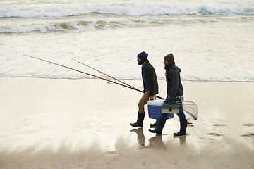 Image showing Calm, fishing and men walking on beach together with cooler, tackle box and holiday conversation. Ocean, fisherman and friends with rods, bait and tools at waves on winter morning vacation at sea.