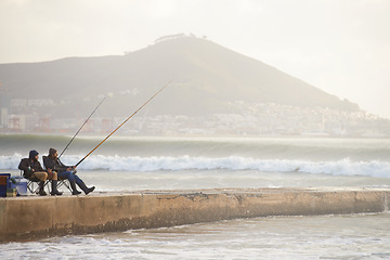 Image showing Fishing, fisherman and people on pier by ocean with rod, reel and equipment to catch fish for hobby. Nature, sports and friends cast line for recreation or adventure on holiday, vacation and weekend