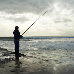 Image showing Casting, fishing rod and man at a beach for water hobby, recreation or stress relief in nature. Pole, line and male fisherman at the ocean for travel, journey or fish sports adventure in Cape Town