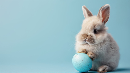 Image showing Adorable Bunny With a Pastel Easter Egg on Blue