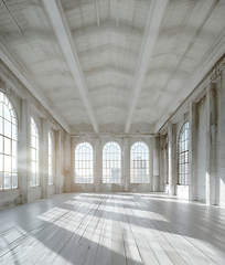 Image showing Spacious hall with wooden floors, lots of windows, and symmetrical fixtures