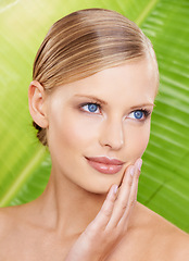 Image showing Woman, smile and natural skincare with leaf for beauty, glow and hydration benefits. Female person, makeup and hand on face with confidence for wellness, detox and daily routine on green background