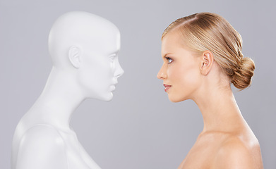 Image showing Studio, woman and mannequin with beauty clone versus artificial standard, perfect and facial wellness. Girl, doll and face in profile for cosmetics, plastic surgery or makeup on grey background.