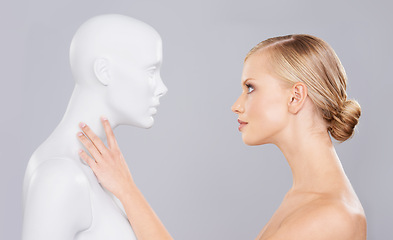 Image showing Studio, woman and mannequin with perfect beauty versus fake standard, identity and facial wellness. Girl, doll and face in profile for cosmetics, plastic surgery or makeup on grey background.