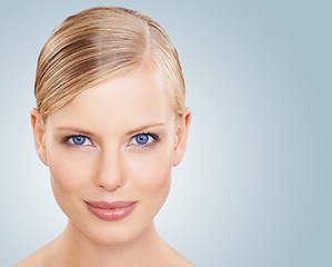 Image showing Portrait, skincare and woman with cosmetics, wellness and beauty on a blue studio background. Face, person or model with shine and makeup with grooming or dermatology with aesthetic, mockup or facial