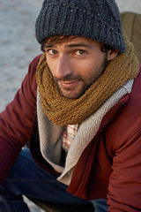 Image showing Portrait, fashion and hipster man at beach on winter morning for travel, holiday or vacation. Face, coast or shore with confident young person in beanie and scarf accessories for cold weather season