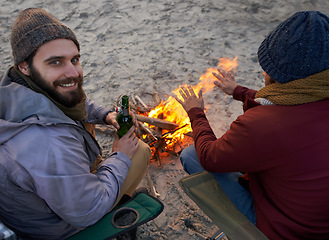 Image showing Campfire, friends and portrait with men and beer by the beach at sunset with vacation and camping. Ocean, outdoor and together with travel and people with journey and fire with conversation by sea