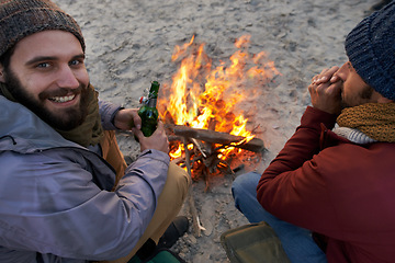 Image showing Campfire, friends and portrait with man and smile by the beach with vacation and camping. Ocean, outdoor and together with travel and people on a trip and journey with fire conversation by sea