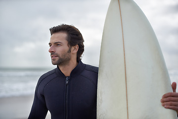 Image showing Surfboard, waves and man on beach for surfing on vacation, holiday and weekend in ocean. Relax, thinking and person in wetsuit for water sports, hobby and exercise for adventure and freedom in sea