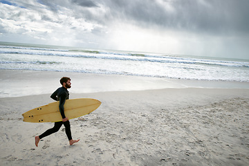 Image showing Surfboard, running and man on beach for surfing on vacation, holiday and weekend in ocean. Relax, waves and person in wetsuit for water sports, hobby and exercise for adventure and freedom in sea