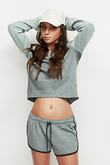 Image showing Portrait, fashion and woman in studio with attitude, confidence and casual trendy style on white background. Cap, face and female model posing in cool, edgy or streetwear clothes or outfit choice