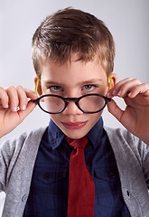 Image showing Glasses, serious and portrait of child in studio for eye care, vision and optical health. Looking, optometry and young boy kid with stylish eyewear or spectacles isolated by white background.
