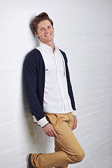 Image showing Smile, fashion and portrait of man by wall with casual, cool and trendy outfit for confidence. Happy, handsome and young male person with attractive style standing by white brick background.