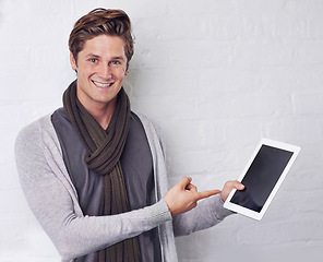 Image showing Happy man, portrait and pointing to tablet screen for advertising or marketing on a white studio background. Young and handsome male person with smile, showing technology display or mockup space