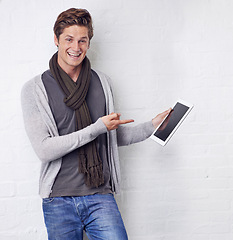 Image showing Excited man, portrait and pointing to tablet screen for advertising or marketing on a white studio background. Happy and handsome male person with smile, showing technology display or mockup space