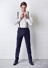 Image showing Man, portrait and fashion with getting ready, confidence and suit with trendy and stylish clothes. Hipster, male person and wall with event, classic and fancy suspenders with dressing formal