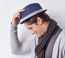 Image showing Man, fashion and hat with confidence for style with wall background as hipster with scarf, clothes or relax. Male person, model and hand with smile in Canada for trendy headwear, cool or happiness