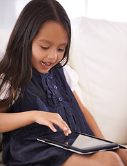 Image showing Little girl, child and tablet on sofa for entertainment, movie or online streaming in living room at home. Face of female person or kid browsing or scrolling on technology for reading ebook at house