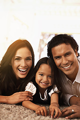 Image showing Happy family, portrait and hug with support for love, bonding or relax together at home. Face of mother, father and little girl, child or young kid with smile for embrace, holiday or weekend on floor