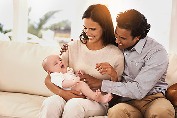 Image showing Happy family, baby and hug on sofa for bonding, support or love together in relax at home. Father and mother holding little child, kid or newborn toddler on living room couch with smile at house