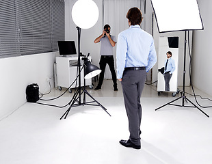 Image showing Photographer, model and lighting with equipment in studio for career, behind the scenes or electronics. Photography, person or working with cameras, flash and shooting gear for photoshoot or passion