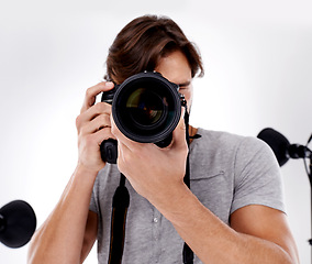 Image showing Man, camera lens and photography with tech in studio, press or media for news on white background. Photographer, photo journalist and creative with paparazzi, equipment and closeup in studio