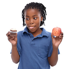 Image showing Kid, apple and cupcake in studio with thinking for chocolate, sugar or diet for nutrition. Black child, planning and decision with choice for lifestyle, fruit or sweet dessert on white background