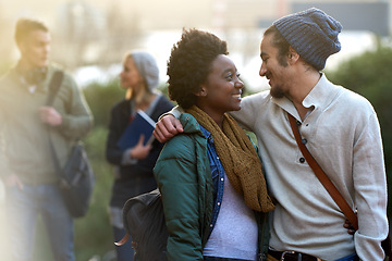 Image showing Students, university and conversation of interracial couple of friends on campus with hug and an embrace outdoor. College, school education and diversity with a happy smile ready for class together