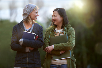 Image showing University, books and conversation with woman friends outdoor on campus together for learning or development. College, education or school with young student and best friend talking at recess break
