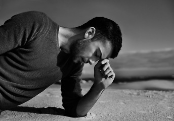 Image showing Depression, sad or man in the desert thinking of travel in summer to relax on holiday vacation. Upset, black and white with face of male person on the ground with anxiety, monochrome or cool style