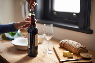 Image showing Hands, opening wine bottle and dinner on table, evening meal with corkscrew and glass, person preparing to drink for enjoyment. Alcoholic beverage, tools with cooking for dining and bread in kitchen