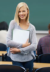 Image showing Happy, woman and portrait of student in classroom for education, knowledge and development with notebook. Female person, smile and confident at campus for academics, growth and learning in university