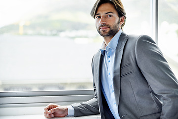 Image showing Business man, entrepreneur and serious by window in portrait, confident and professional in office. Male person, employee and pride for career at startup company, professional and expert at workplace