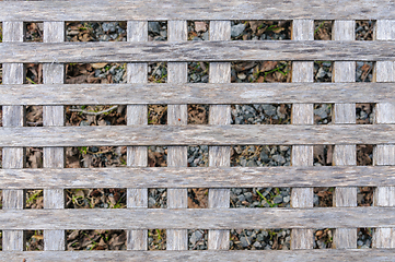 Image showing Close-up view of a wooden lattice structure over gravel ground