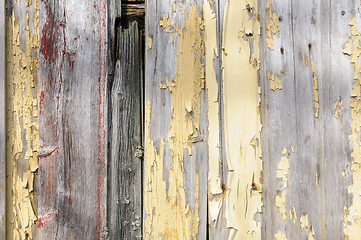 Image showing Worn and weathered wooden boards with peeling yellow paint