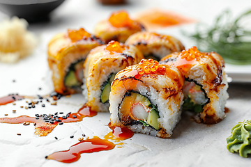 Image showing Delicious Sushi Rolls with Savory Toppings and Sauce