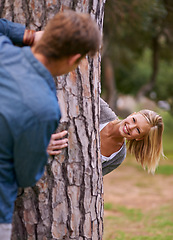 Image showing Couple, park and smile with playing for hide and seek, love and happiness in outdoor setting in Los Angeles. Relationship, romance and fun day in forest for lifestyle, wellness and relax for bonding