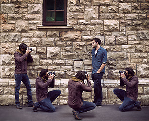 Image showing Model, photoshoot and photographer in city with man or paparazzi filming on street for press. Creative, project and person posing for cameraman shooting on wall outdoor with talent and fashion