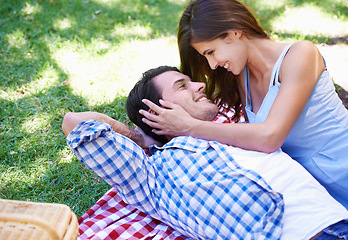 Image showing Man, woman and relax in park for picnic on holiday for summer bonding, happy or outdoor. Couple, smile and embrace on blanket on grass for valentines day or dating connection or rest, love or weekend