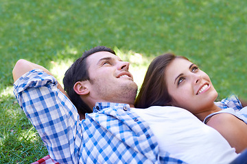 Image showing Couple, smile and relax on grass for connection, bonding and love in park outdoors. Happy, man and woman in summer for holiday, vacation or date for healthy relationship in field with closeup