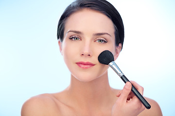 Image showing Woman, portrait and makeup brushes in studio with cosmetic, beauty tools or product application for skincare. Model, face and confidence with skin wellness, cosmetology or grooming on blue background