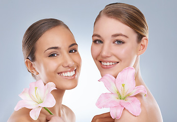 Image showing Happy woman, portrait and skincare with flowers for natural beauty, makeup or cosmetics on a blue studio background. Young female friends or models smile in satisfaction for spa or facial treatment