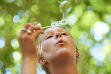 Image showing Lady, game and bubbles of water and soap, freedom with happiness, summer and blurred background. Outdoors, gen z and play in park for peace and activity with wand in sunshine, calm and nature