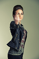 Image showing Model, studio and punk with gesture, fashion and rebel for expression, anger and style. Woman, leather jacket and middle finger for attitude, confidence and individuality with portrait and rock star